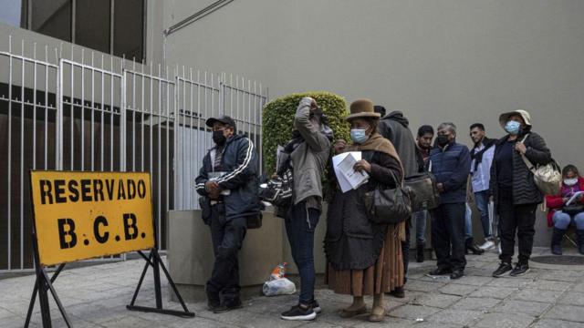 Personas esperando junto al Banco Central de Bolivia para conseguir dólares.