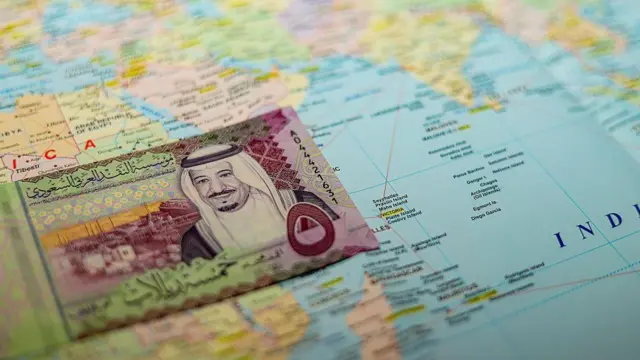 Dünya haritası üstünde bir Arap banknotu