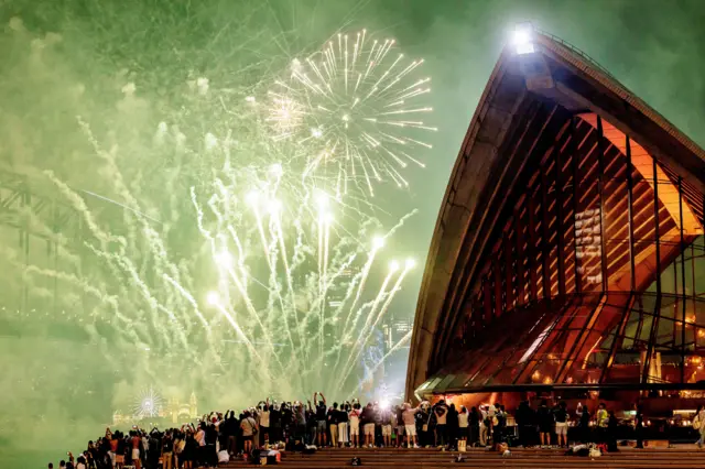 Сиднейдин атактуу фейерверктерин көрүү үчүн миңдеген адам аптаптуу күндүн алдында сааттар бою күтүшөт (учурда Сиднейде жай мезгили)