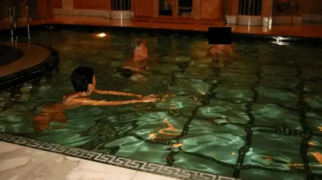 Билл Клинтон в бассейне с двумя женщинами, лиц которых не видно