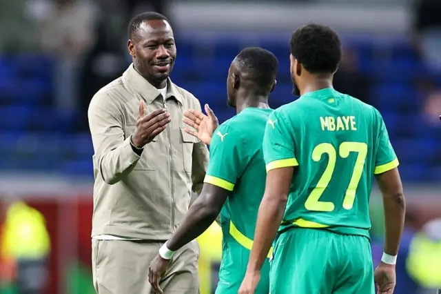 Pape Thiaw, sélectionneur du Sénégal, félicite Sadio Mané et Ibrahim Mbaye, joueurs sénégalais, pour leur victoire lors du huitième de finale de la Coupe d'Afrique des Nations opposant le Sénégal au Soudan au stade Ibn Batouta, le 3 janvier 2026 à Tanger, au Maroc. 