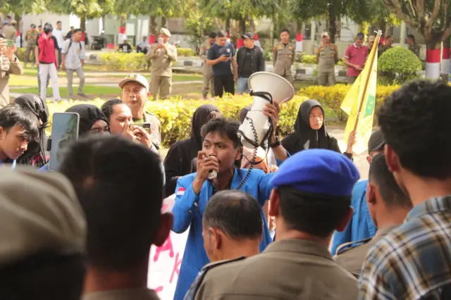 Seorang pemuda sedang berorasi.