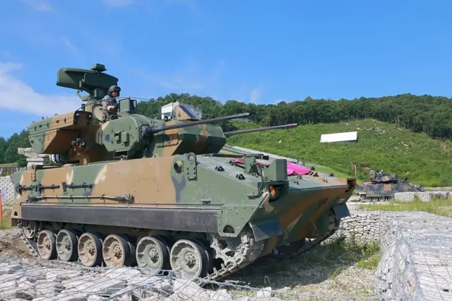 Південнокорейський солдат на зенітній установці під час спільних навчань з американською армією, та тлі зеленого пагорба та блакитного неба