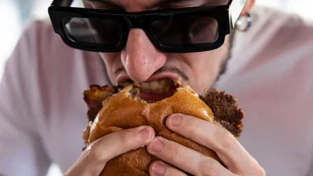 hombre comiendo una hamburguesa
