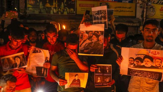 إيرانيون يحملون صوراً للمفقودين في حادثة تحطم الطائرة من بينهم الرئيس ووزير الخارجية