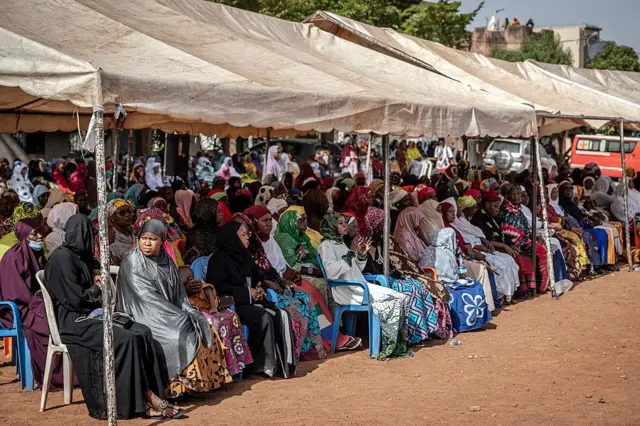 Des personnes en deuil assistent aux funérailles d'Amadou Bagayoko au Mali. Ils sont photographiés assis sous une tonnelle, alors que la cérémonie se déroule.