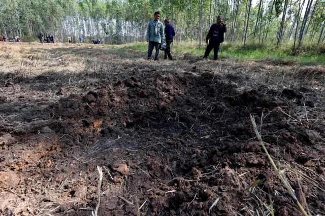 ชาวบ้านกำลังเดินดูพื้นที่นาหลังจรวด BM 21 ตก ที่ อ.บ้านกรวด จ.บุรีรัมย์