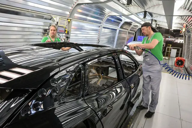 Volkswagen montaj işçileri, 24 Şubat 2026'da Almanya'nın Emden kentindeki Volkswagen elektrikli otomobil fabrikasının boyahanesinde ID serisi elektrikli araçlarda son kontrolleri ve düzeltmeleri yapıyor. 