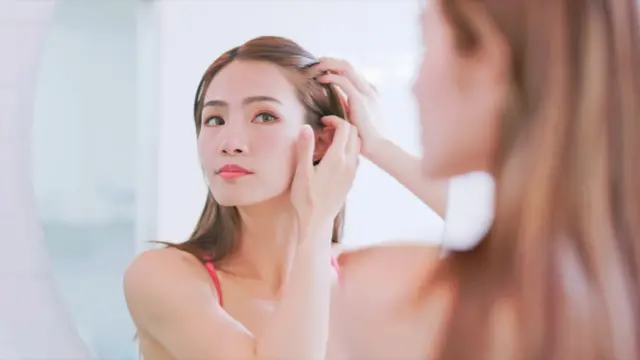 หญิงสำรวจผมตัวเอง