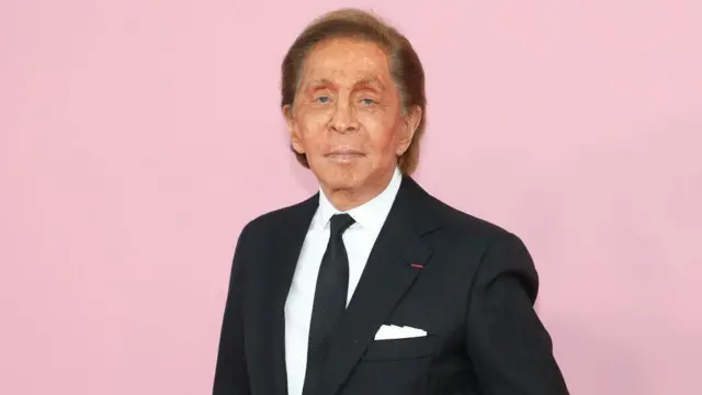 Valentino Garavani compareceu à cerimônia de entrega dos prêmios CFDA de 2019 no Museu do Brooklyn, em Nova York, no dia 3 de junho de 2019, vestindo um terno preto e posando contra um fundo rosa.