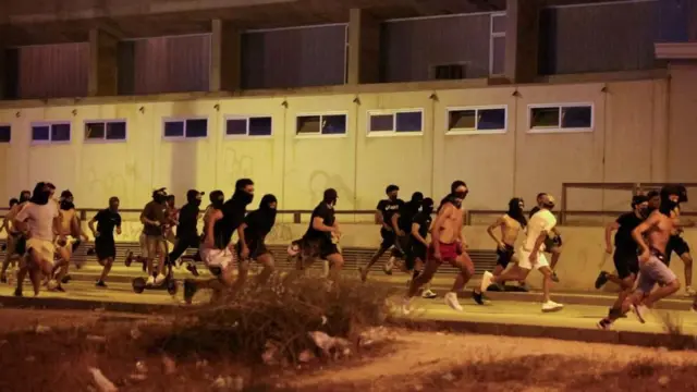 ጭምብል ያደረጉ ወጣቶች በምሽት እየሮጡ