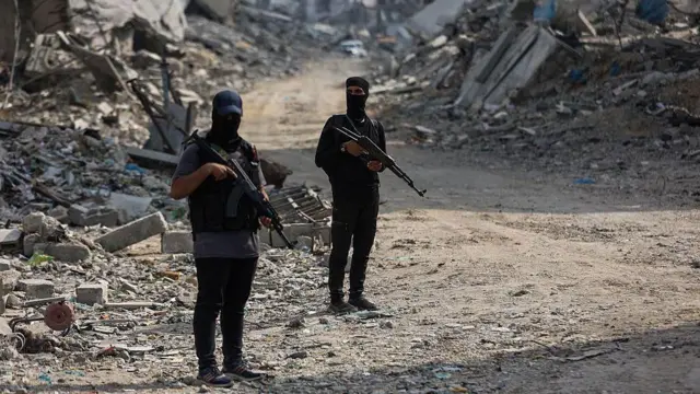 Combatientes de Hamás armados en una calle con escombros