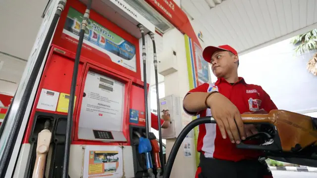 Seorang petugas mengisi bahan bakar minyak di SPBU
