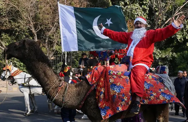 Wani Kirista a ƙasar Pakistan yana murnar Kirsimeti a kan raƙumi.