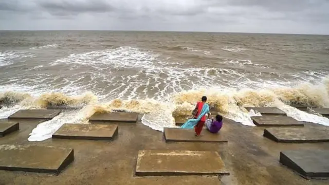 கடற்கரையோரமிருந்து கடலை பார்க்கும் மக்கள் 
