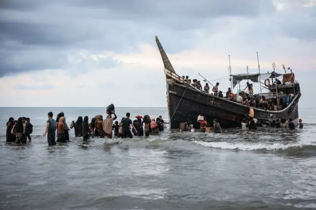Rohingya refugees return to a boat after locals turn them away.