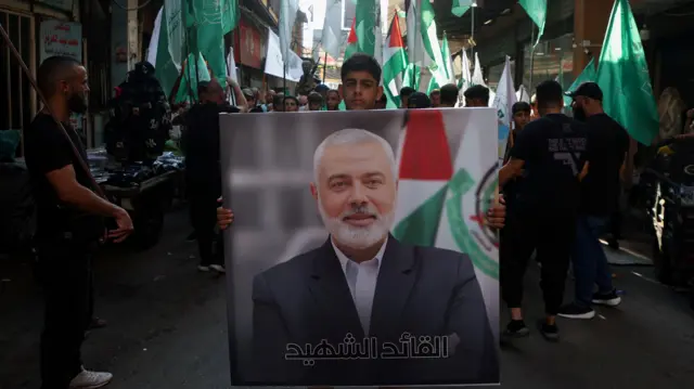 Palestinian boy carrying poster of Haniyeh during a protest march