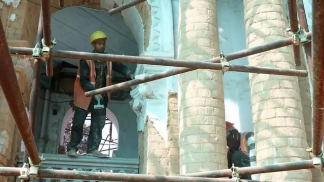 सन् २०१५ को बिनाशकारी भूकम्पमा सिंहदरबारमा ठूलो क्षति पुगको थियो। त्यसको रेट्रोफिटिङ गर्ने क्रममा काम गर्दै हेल्मेट र सुन्तला रङ्गको ज्याकेट लगाएका दुई मजदुरहरू