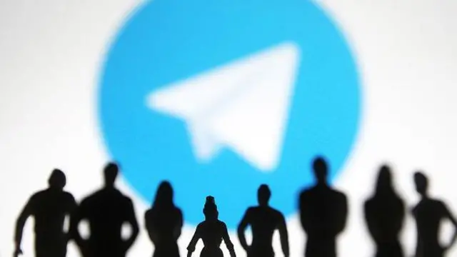 Колаж, на якому зобрежений логотип телеграма і чорні силуети людей на його фоні. 