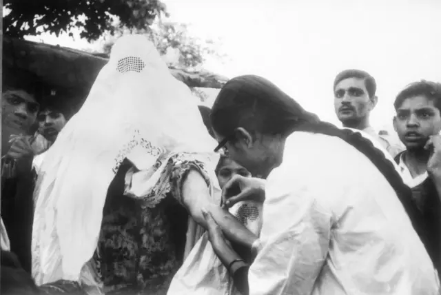 Une femme avec burka reçoit le vaccin contre la viruela.