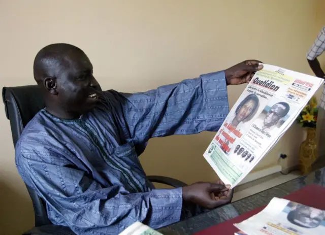 Le journaliste sénégalais Madiambal Diagne regarde une édition de son journal à son bureau, le 26 juillet 2004, après avoir été libéré de prison.