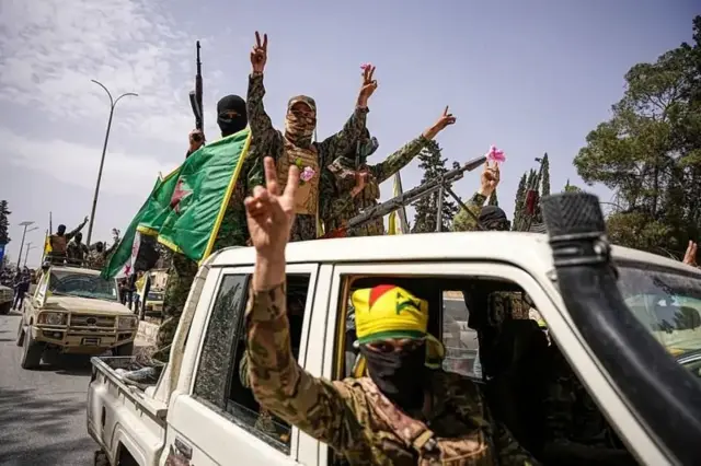 چند نیروی نظامی سوار بر خودرو به علامت پیروزی دستشان را بالا بردند