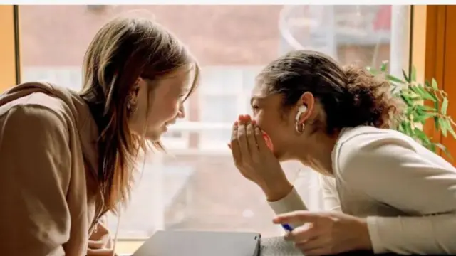 Aworan awon obinrin meji mi-in ti wọn n sọrọ kẹlẹkẹlẹ