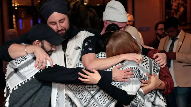 La gente se abraza al conocer los resultados de Michigan. 