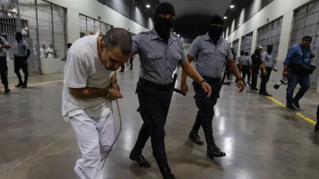 एक अपराधी को जेल में ले जाते सुरक्षाकर्मी