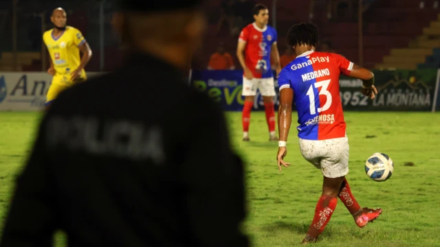 Edgar Medrano, atacante do FAS, chuta a bola de costas. Sua camisa mostra o número 13 com seu sobrenome, no Estádio Óscar Alberto Quiteño em 11 de outubro de 2025, durante o jogo entre o time local FAS e o Municipal Limeño, em Santa Ana, El Salvador.