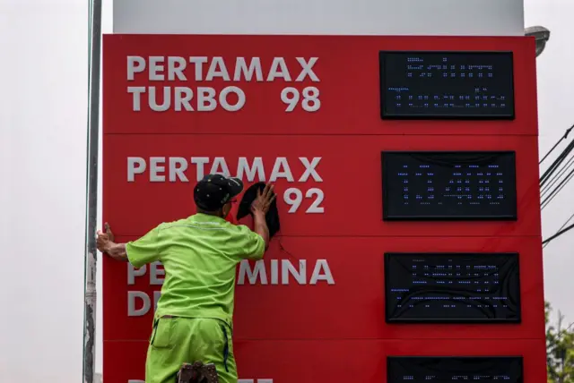 Petugas SPBU membersihkan papan harga di salah satu SPBU yang terletak di Bogor, Jawa Barat, Indonesia, Kamis (2/11).
