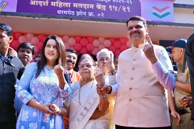 देवेंद्र फडणवीस अपनी मां (बीच में) और पत्नी (बाएं) के साथ