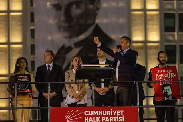 Özgür Özel sahnede konuşma yapıyor. Arkasında Dilek İmamoğlu var.