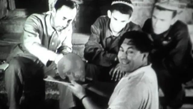 Қабрдан чиқарилган бош чаноғини ушлаб турган антрополог Михаил Гарасимов.