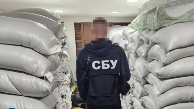 Человек в форме с надписью СБУ у стопки мешков