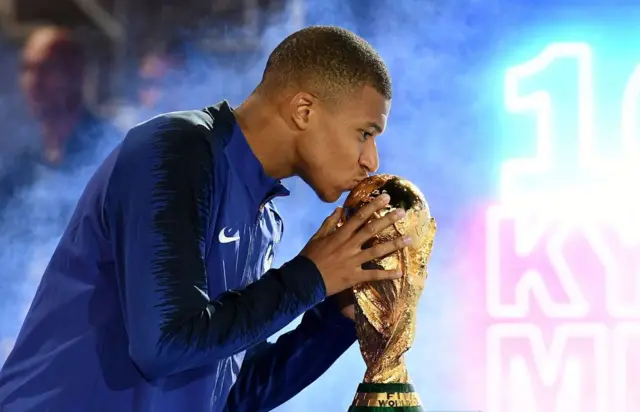 L'attaquant français Kylian Mbappé embrasse le trophée de la Coupe du monde 2018 lors d'une cérémonie célébrant la victoire de la France avant le tour d'honneur à la fin du match de Ligue des Nations de l'UEFA opposant la France aux Pays-Bas au Stade de France, à Saint-Denis, au nord de Paris, le 9 septembre 2018. 