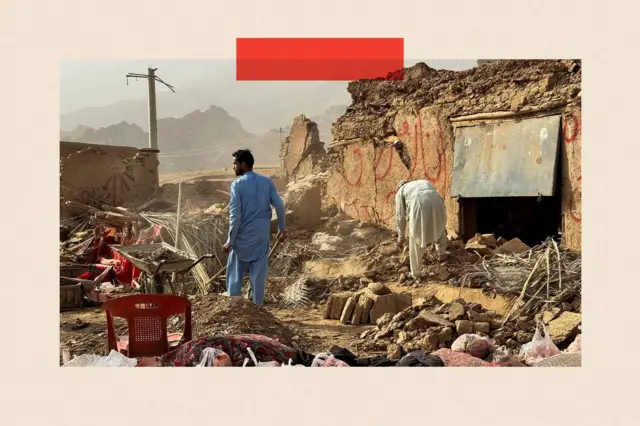 Un hombre con túnica y pantalones azules inspecciona los daños causados por un terremoto. Está de pie entre los escombros de una casa, mirando hacia las montañas en la distancia. Otra figura a la derecha se inclina sobre