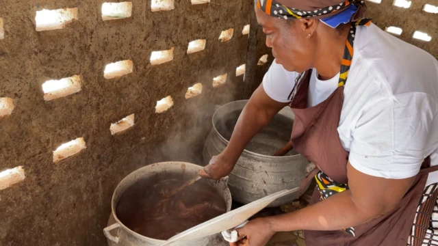 Nathalie Dago en train de remuer du cacao dans une marmite