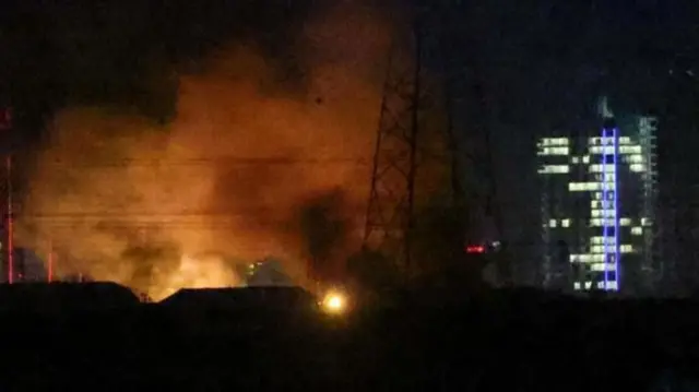 Erbil Havaalanında gece karanlığında ışıklı bir bina yanında patlama