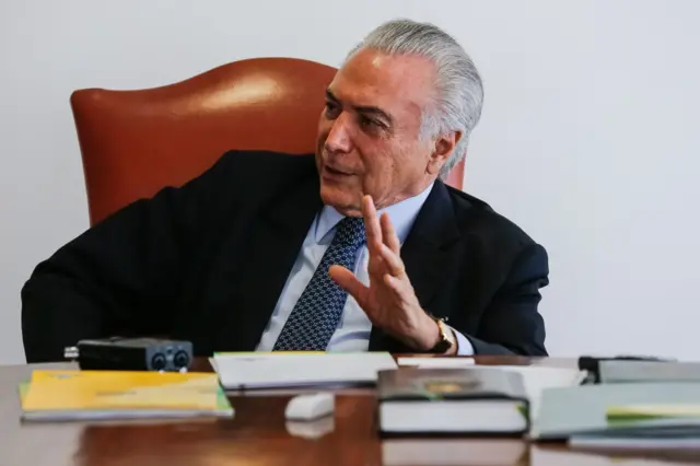 Ex-presidente Michel Temer (MDB),betnacional app atualizado 20242016. Ele está diantebetnacional app atualizado 2024uma mesa com vários objetosbetnacional app atualizado 2024trabalho e um gravador ligado. Usa um terno escuro, camisa azul-clara e gravata azul escura 