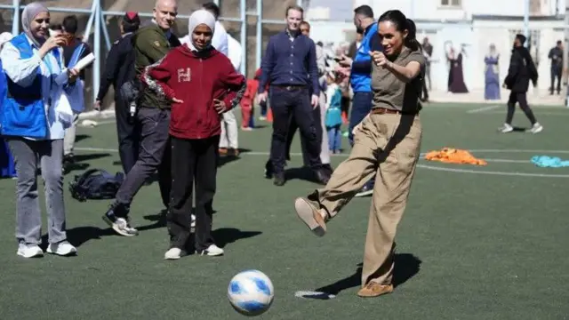 ميغان تركل الكرة بينما يشاهد آخرون.