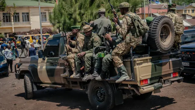 M23 rebel soldiers ride on the back of a pick-up truck in Goma