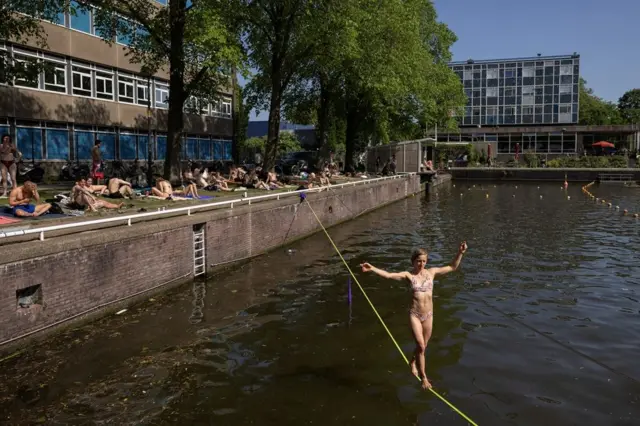 vrućina u amsterdamu, devojka hoda po živi iznad kanala u amsterdamu
