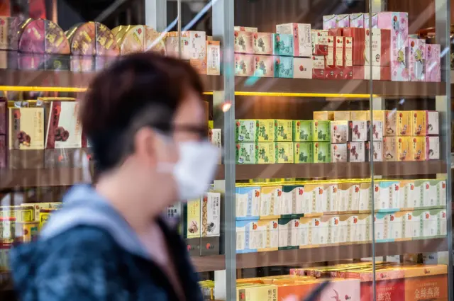 Un hombre pasa frente a una vidriera con productos de medicina tradicional china en Hong Kong