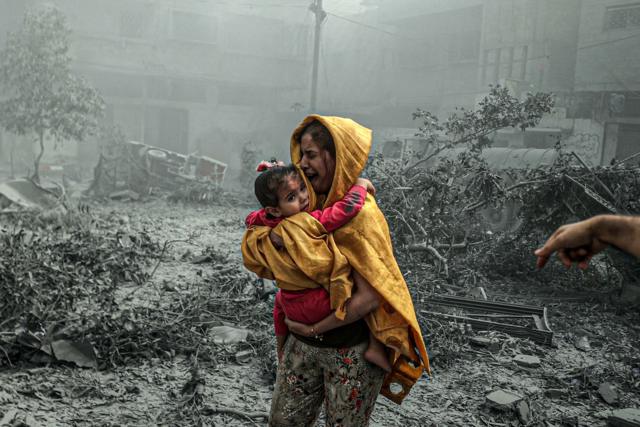 Hình ảnh một phụ nữ bế một bé gái trong một cuộc không kích của Israel nhằm vào Thành phố Gaza