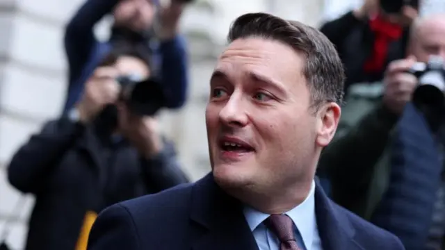 スーツ姿のストリーティング氏が、歩きながら後ろを振り返っている