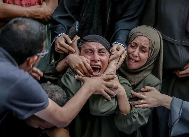 سيدة تصرخ وبجوارها سيدة تبكي خلال تشييع جنازة من سقطوا في الهجوم الإسرائيلي على مدينة غزة، غزة، في 2 سبتمبر/أيلول 2025.
