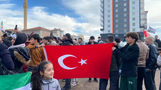 Türkiye bayrağı açan iki genç, önüned bir kız çocuğu