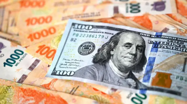 Billetes argentinos y dólar.