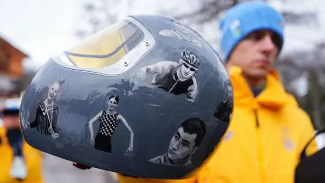 Украинский саночник Владислав Гераскевич показывает крупно на камеру свой шлем с фото украинских спортсменов, погибших на фронте и в тылу, за который МОК отстранил его от Олимпиады